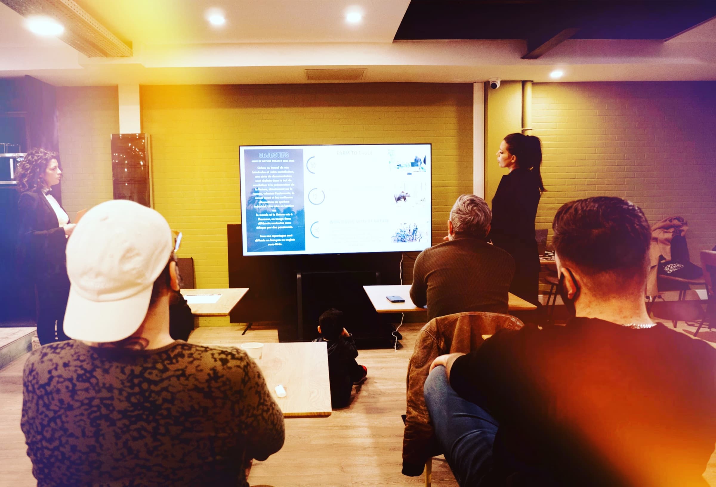 An audience watching a presentation in a small conference room